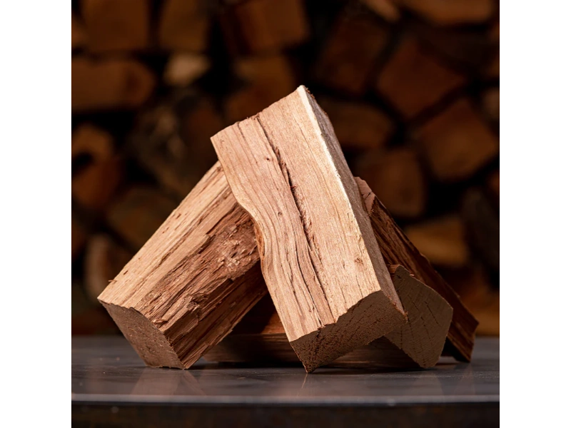 Split Cherry Firewood stacked in front of log pile.