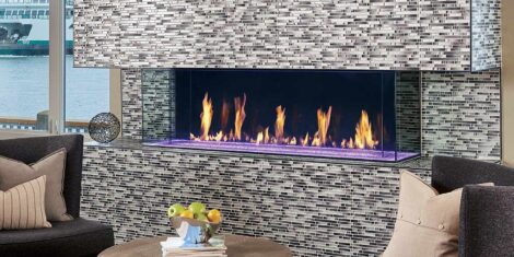 Glass Covered DaVinci Fireplace, visible on three sides, stone chimney with gas flames. By Dreifuss Fireplaces