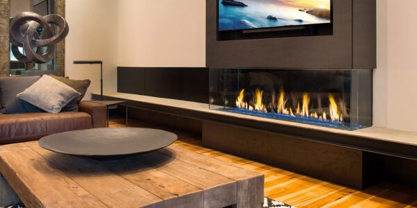 DaVinci Bay Linear fireplace under wall mounted TV. Flame is gas fed and visible on three sides. Sold by Dreifuss Fireplaces.