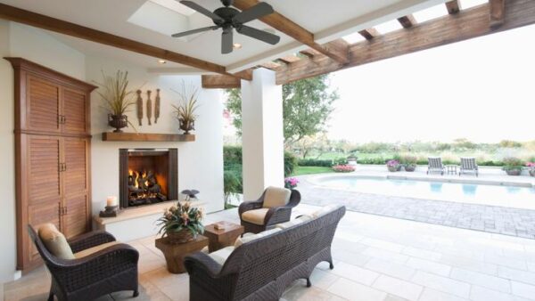 Outdoor Commercial Fireplace under pergola with outdoor furniture for seating area