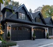 Black glass garage door enhancing a contemporary house's curb appeal.