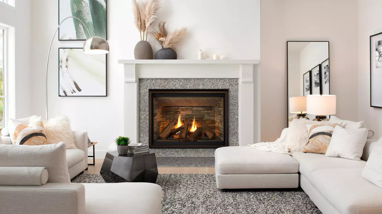 A modern living room with a stone-framed fireplace, white sofas, abstract art, and minimalist decor.