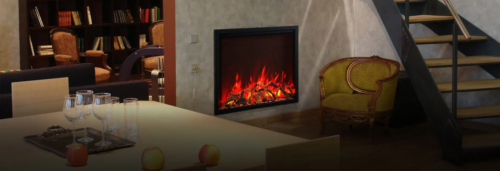 A modern living space with an electric fireplace, an elegant chair, a staircase, and a bookshelf, complemented by a dining table with glassware.